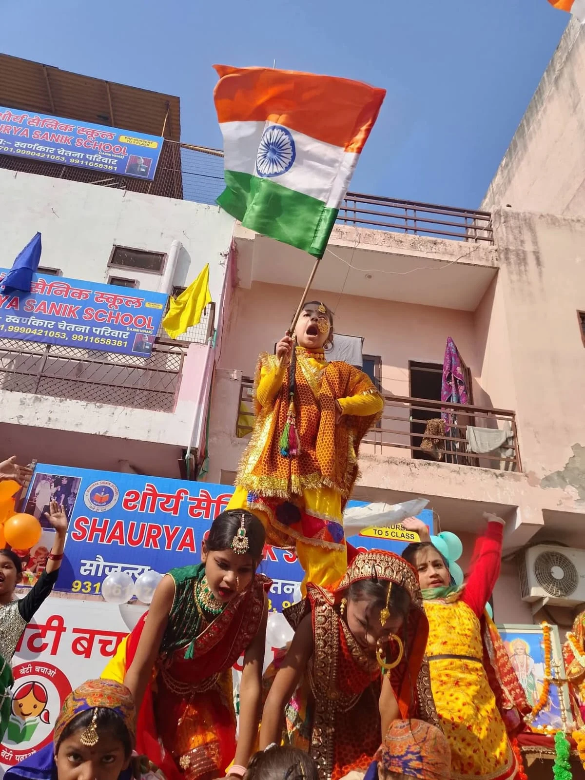 Children performing with the Indian flag at the school.
